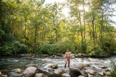 Senior portrait of a swimmer standing in a West Michigan stream