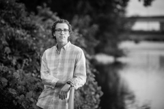 Senior boy poses along the river in down town Grand Rapids male senior pictures