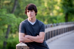 Senior guy poses on a bridge for male high school senior portraits near Grand Rapids