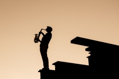 Sunset silhouette of senior boy with a saxophone in Grand Rapids senior portrait