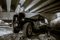 Male high school senior portrait of a boy with his Jeep near Grand Rapids