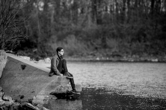 Creative male high school senior portrait of a guy overlooking water near Grand Rapids Michigan