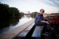 Male senior portrait near the Grand River in urban Grand Rapids