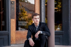 Well dressed senior guy poses in urban Grand Rapids for male high school senior portraits