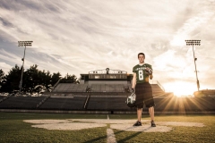 Grand Rapids male senior football player poses on the field for sunset senior portraits