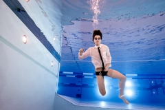 Grandville swimmer boy poses underwater for male senior portraits near Grand Rapids